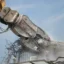 Närbild på en pulveriserare som krossar ner en betongbyggnad.