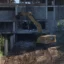 En rivningsgrävare använder en HP demoleringssax för att riva ner en betongbyggnad.