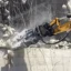 En kombisax på en rivningsplats klipper och krossar ner en byggnad.
