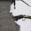 En höjdrivare klipper sönder en betongvägg.