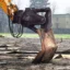 En grävmaskin klipper plåt med plåtnibbler.