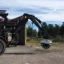 En Huddig traktorgrävare med ett fräshjul monterat.