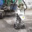 En grävmaskin med rotationsfräs fräser upp ett schakt för VA.