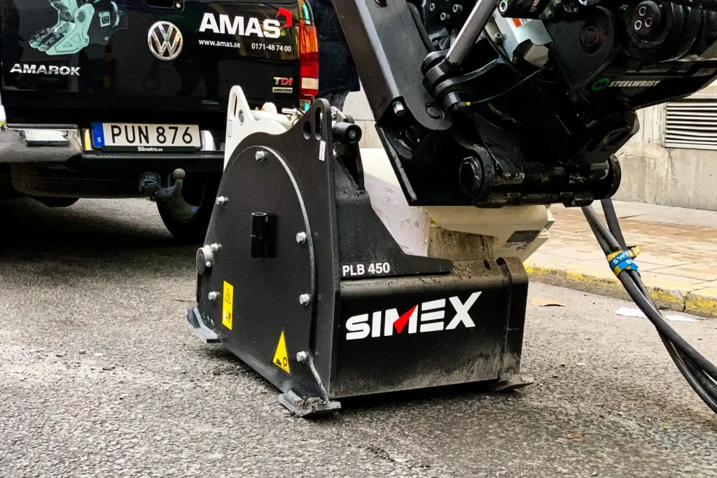 En imponerande Simex PLB450 asfaltsfräs monterad under rotorn på en robust Volvo EWR150E