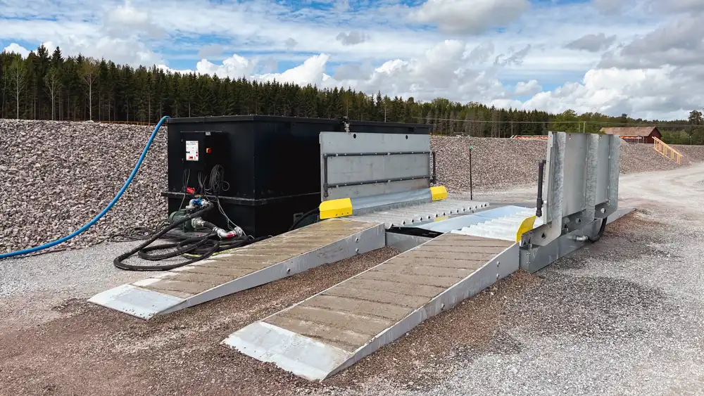 Översiktsbild på den kompletta mobila hjultvättsanläggningen från Spraystream hos Orca Entreprenad i Läggesta. Ramp, körbana och återvinningstank syns tydligt.