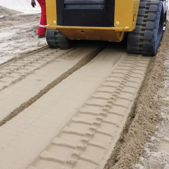Strandrensare siktar sand och tar bort skräp vid strandstädning.