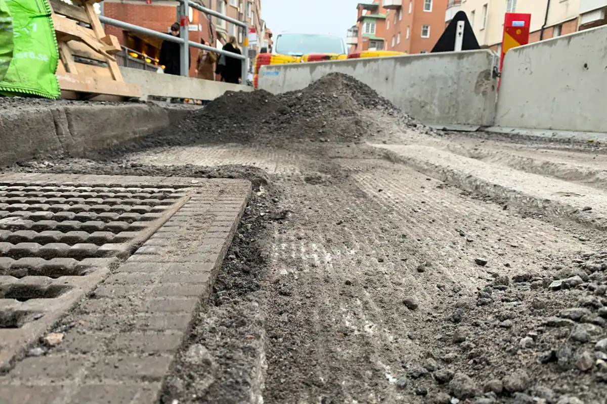 Fräst asfalt runt ett brunnslock som visar hur Simex asfaltsfräs skapar ett jämnt och precist underlag vid detaljerade arbeten.