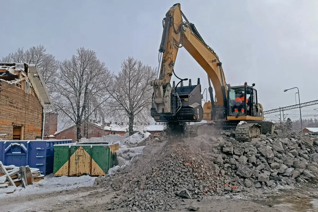 Simex CBE malningsskopa monterad på grävmaskin som maler rivningsbetong i vintermiljö.