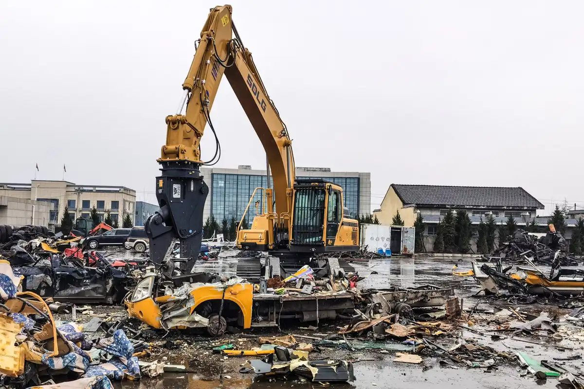 VTN fordonsdemonterare som krossar och demonterar ett bilvrak på skrotgård för effektiv återvinning.