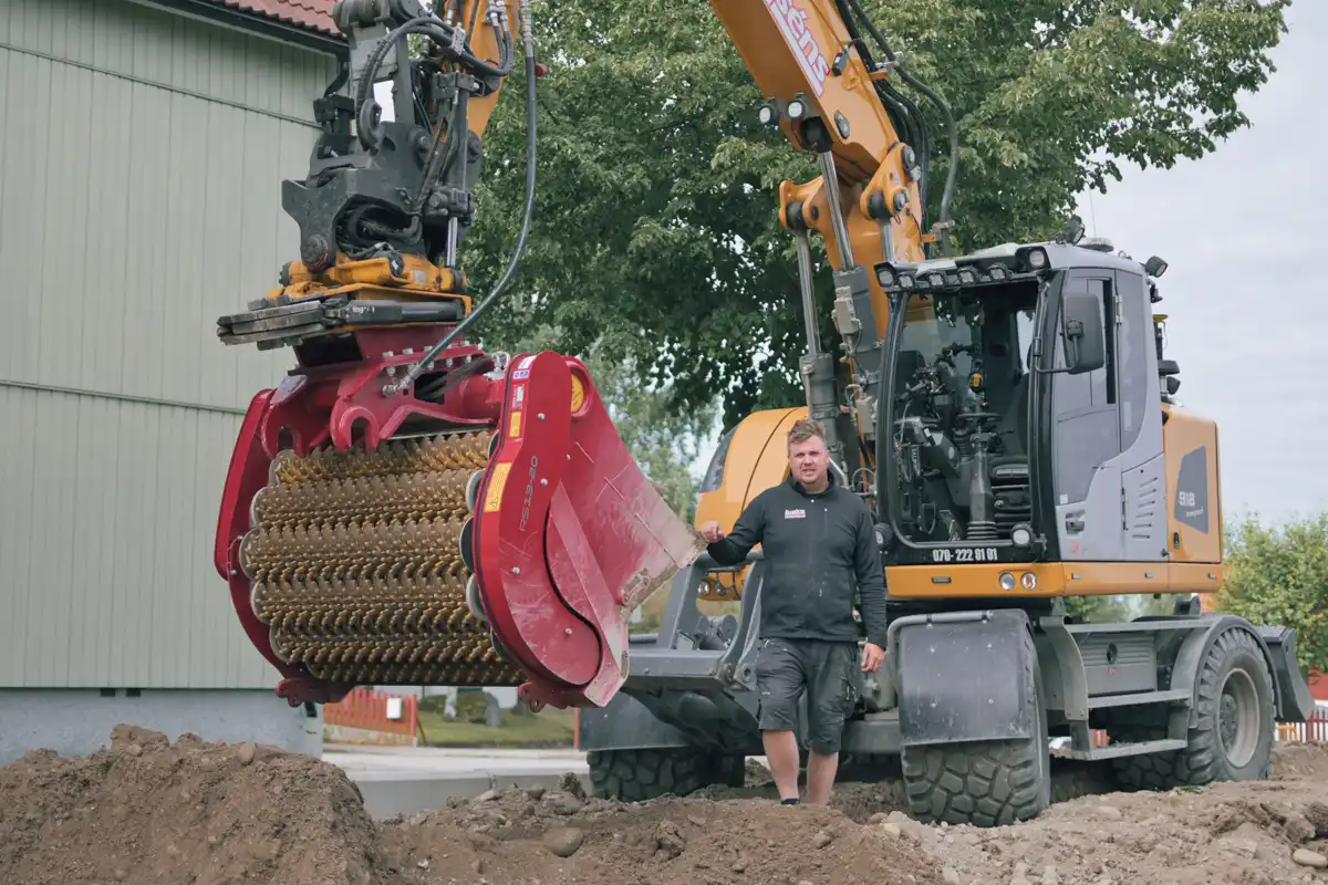 Närbild på rotortrumma i siktskopa för effektiv sortering av jord, sten och schaktmassor.