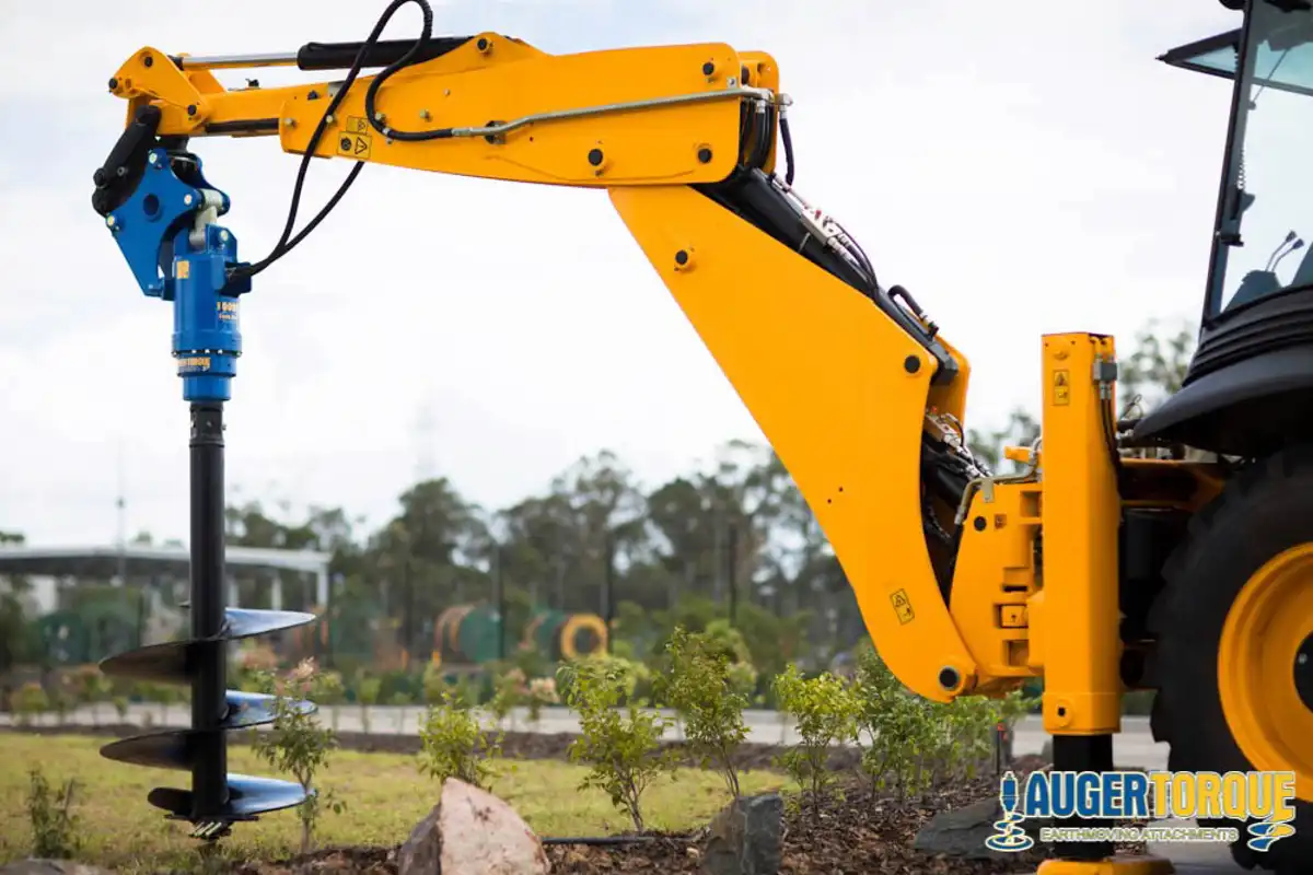 Jordborr monterad på grävlastare för håltagning och stolpsättning